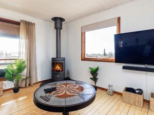 a living room with a fireplace and a table at Holiday home Vordingborg X in Vordingborg