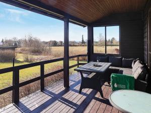 eine abgeschirmte Veranda mit einem Tisch und einer Couch in der Unterkunft Holiday home Vordingborg X in Vordingborg
