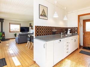 a kitchen with a sink and a living room at Holiday home Vordingborg X in Vordingborg
