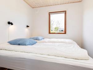 Cette chambre blanche comprend un grand lit blanc et une fenêtre. dans l'établissement Holiday home Vordingborg X, à Vordingborg