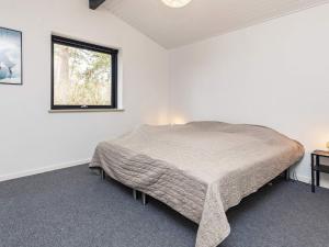 a bedroom with a bed in a room with a window at Holiday home Væggerløse XXV in Marielyst