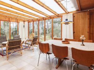 a dining room with a table and chairs and windows at 6 person holiday home in Væggerløse-By Traum in Marielyst