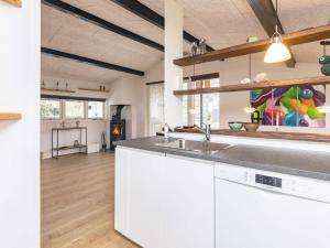 una cucina con armadi bianchi e lavandino di Holiday home Otterup XII a Otterup