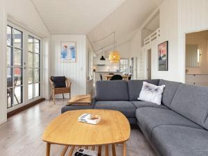 - un salon avec un canapé bleu et une table dans l'établissement Holiday home Martofte XI, à Martofte