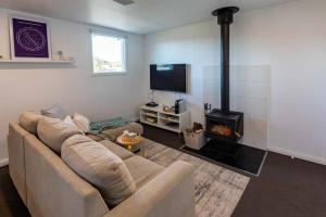 a living room with a couch and a fireplace at Pandora Beach House in Venus Bay