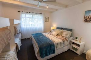 a bedroom with a large bed and a window at Pandora Beach House in Venus Bay