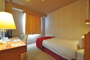 a hotel room with a bed and a desk at Annex Hotel Abe in Kurihara
