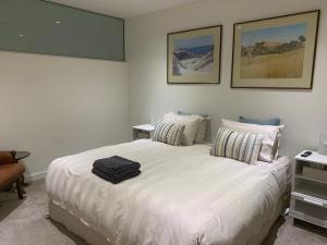 a bedroom with a large white bed with two pillows at SEABREEZE at Victor Harbor in Victor Harbor