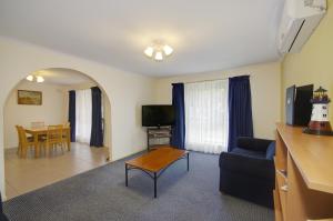 sala de estar con sofá y mesa en Parkwood Motel & Apartments en Geelong