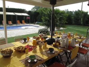 a table set up for a meal next to a pool at L'étape Provencale in Cabriès