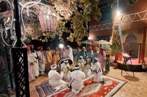 a group of people praying in a room with a crowd at Riad Chay & Boutique in Ouarzazate