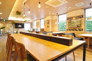 un restaurante con una gran mesa de madera y sillas en Annex Hotel Abe, en Kurihara