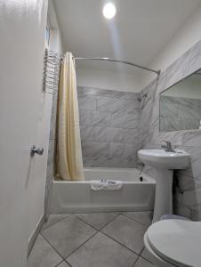 een badkamer met een wastafel, een bad en een toilet bij BEST MOTEL in Barstow