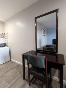 a desk with a mirror and a chair in a room at BEST MOTEL in Barstow