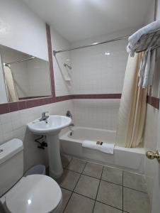 uma casa de banho com um lavatório, um WC e uma banheira em BEST MOTEL em Barstow