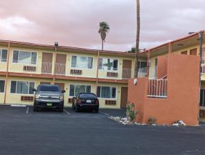 two cars parked in a parking lot in front of a motel at BEST MOTEL on Historic Route 66, Barstow in Barstow