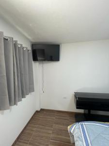 にあるllacaのベッド1台と壁掛けテレビが備わる客室です。