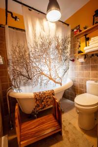 a bathroom with a bath tub with a tree shower curtain at Bed and Breakfast Panorama in Saint-Laurent-de-l'ile d'Orleans