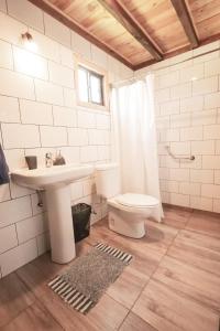 a white bathroom with a sink and a toilet at Cabañas los 7 lagos in Panguipulli