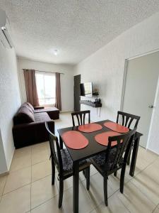 a living room with a table and chairs and a couch at Condominio en Playa del Carmen c/alberca in Playa del Carmen