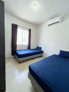 a bedroom with two beds and a window at Condominio en Playa del Carmen c/alberca in Playa del Carmen