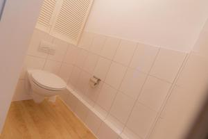 a white bathroom with a toilet in a room at Wohnung-C-305 in Böhl +5 photos