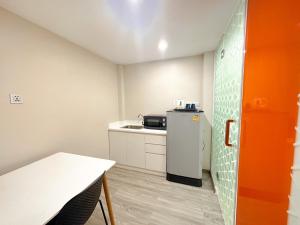Il comprend une petite cuisine équipée d'un réfrigérateur et d'une table. dans l'établissement Hotel Z zpaze, à Bangkok