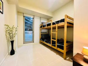 Cette chambre comprend 2 lits superposés et une fenêtre. dans l'établissement Azure 2 Bedroom Pool View Balcony, à Manille