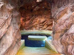 une grotte avec un lit creusé dans la roche dans l'établissement Grande Caribbean Condo Resort, à Pattaya (sud)