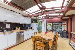 an open kitchen with a wooden table and chairs at Black Forest Motel in Macedon