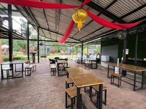 - un pavillon avec des tables et des chaises et un rideau rouge dans l'établissement PLAY at Lot 31 Eco Orchard Melaka, 