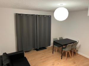 Sala de estar con mesa y cortina gris en Entire house with parking en Mánchester