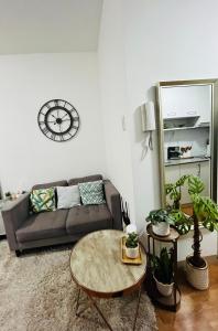 sala de estar con sofá y mesa en Lovely studio unit with fast Wi-Fi and Netflix, en Tagaytay