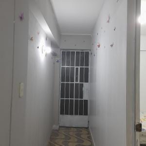um corredor com uma porta com borboletas na parede em Travel house ica em Ica