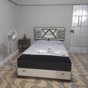 um quarto com uma cama com dois chinelos em Travel house ica em Ica