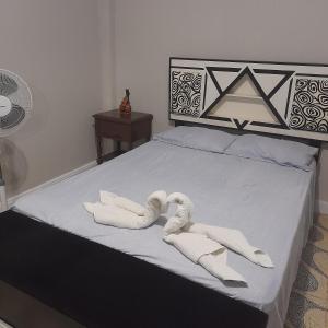 dois cisnes feitos de toalhas sentadas numa cama em Travel house ica em Ica