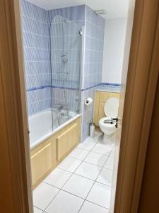 a bathroom with a tub and a toilet and a shower at Riverside Private Room TowerBridge in London