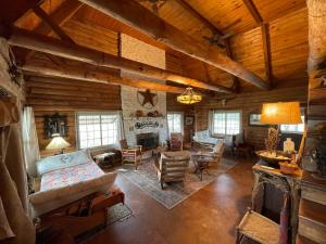 a large living room with a fireplace in a log cabin at Doe Creek Horse Ranch in Bandera