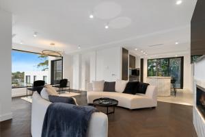 a living room with white furniture and a fireplace at Luxury Waterside Home Sanctuary in Sydney