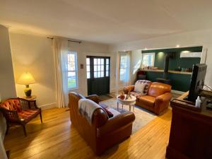 ein Wohnzimmer mit 2 Sofas und einem TV in der Unterkunft Family Summer House in the Eastern Townships in Ayer's Cliff