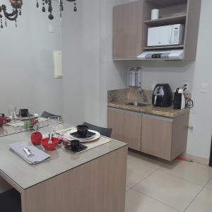 a kitchen with a table and a counter top at Flat - VISTA PARA PISCINA in Brasília
