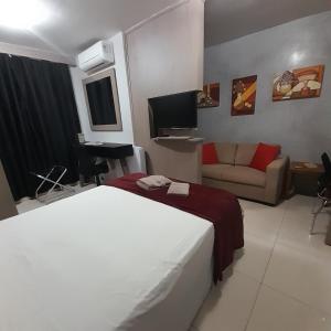 een hotelkamer met een bed en een bank bij Flat - VISTA PARA PISCINA in Brasilia