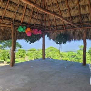 a pavilion with colorful balloons hanging from a straw roof at Ecohotel La Reserva in Piojó