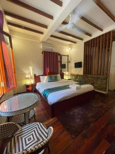 1 dormitorio con 1 cama, mesa y sillas en Chaluenxay Xiengthong Place, en Luang Prabang