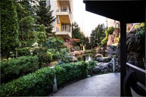 ブカレストにあるGarden Oasis Studioの池と建物のある庭園の眺め