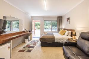 a large bedroom with a bed and a couch at Black Forest Motel in Macedon