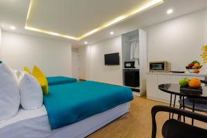 a bedroom with a blue bed and a table at Lyn's Hotel & Apartment in Da Nang