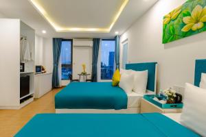 a hotel room with two beds and a kitchen at Lyn's Hotel & Apartment in Da Nang
