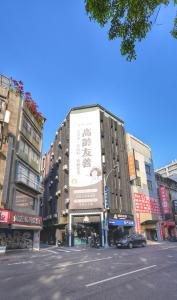 una strada cittadina con un edificio con un grande cartellone pubblicitario di Welove meworld Inn a Taipei