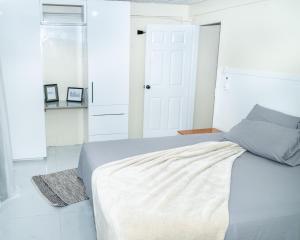 1 dormitorio blanco con 1 cama y suelo blanco en Francis Nook Belle Garden Room en San Juan